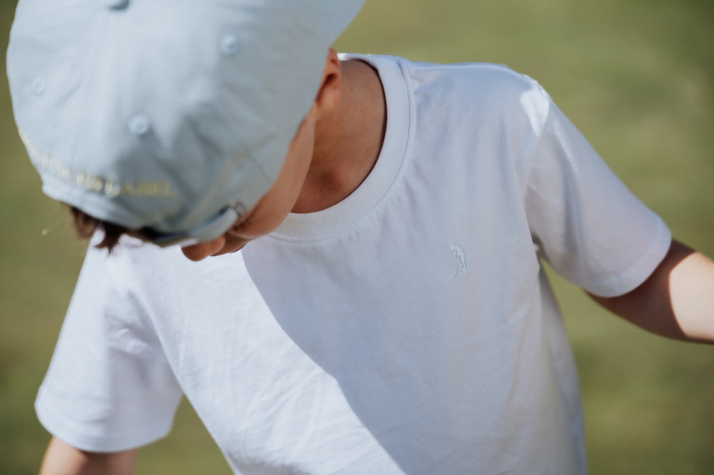Child wearing white tee.