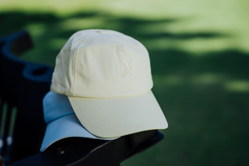 Yellow cap on a golf cart, with grass in the background.