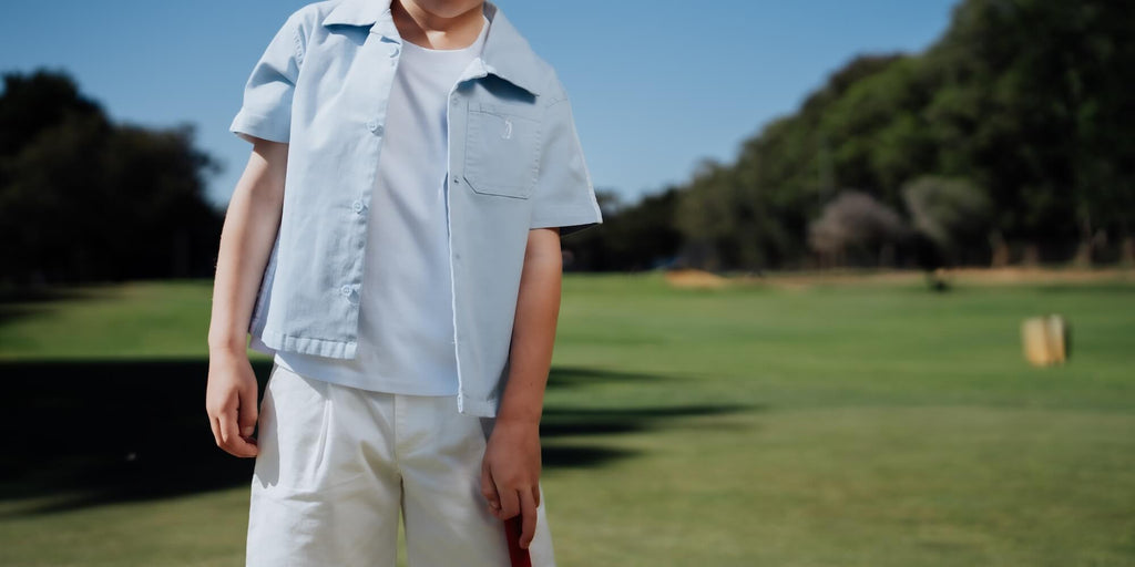 Child wearing blue button up and playing golf.